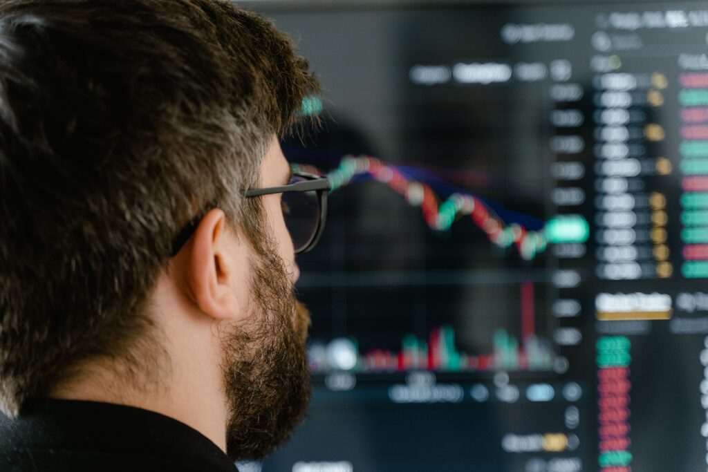 Hombre observa con atención un gráfico de inversión en su pantalla, evaluando si la plataforma es legítima antes de invertir en criptomonedas